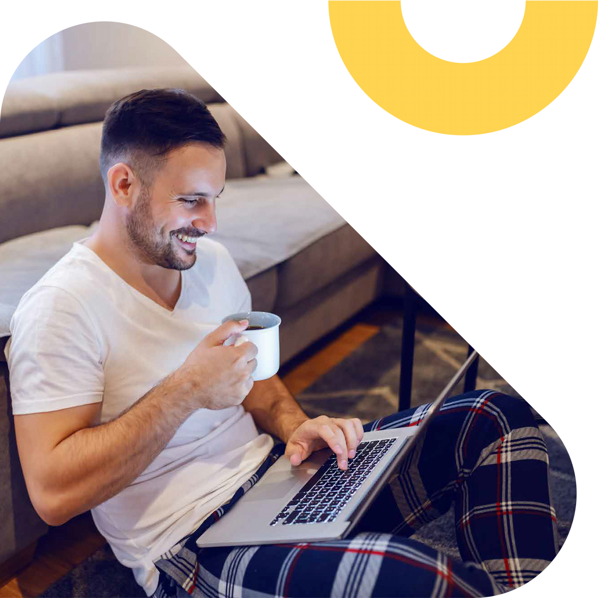 Person drinking coffee and smiling while using a laptop