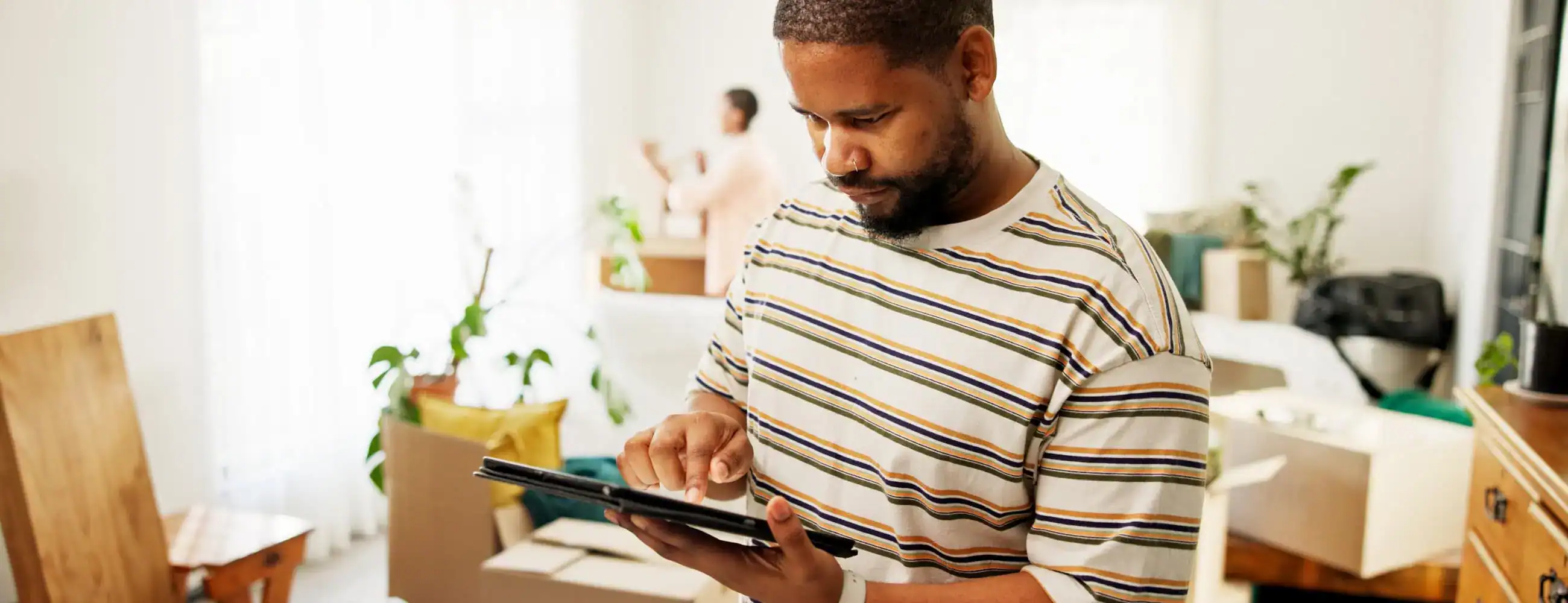 A man using a tablet to organize his move on moving apps.