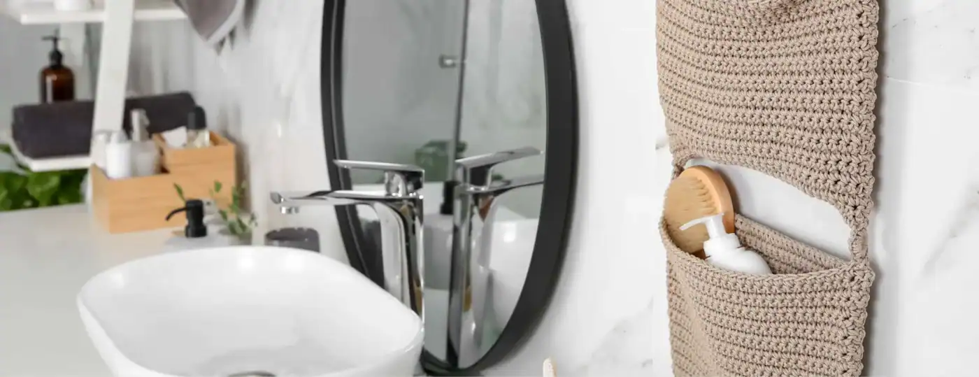 Modern white bathroom with round mirror, vessel sink, and a woven hanging storage basket on the wall